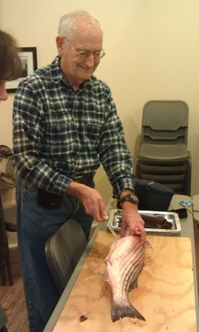 An older participant prepares the fish he caught during Delaware Seashore State Park’s Gilled to Grilled program.