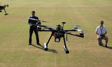 Christopher Vo, left, and Ted Markson fly quadcopters on the intramural fields at George Mason University in Fairfax, Virginia.