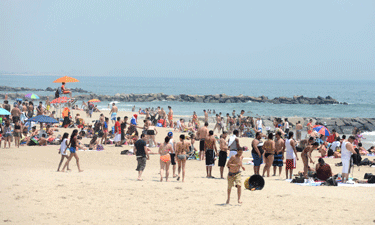 Visitors frolic in the surf and sun at Rockaway Beach in Queens, New York City. 